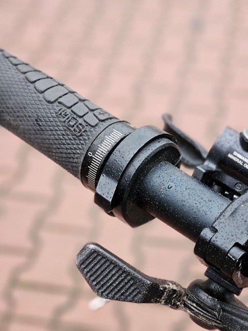 Zbliżenie na manetkę i chwyt na kierownicy roweru.